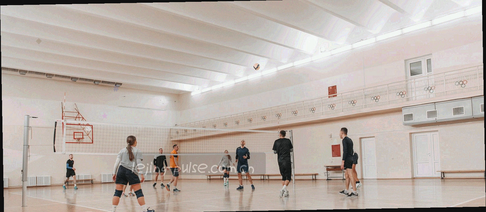 夜场比赛灯光下的球场边线与看台，灯光在冷色天空里排成细线，画面中没有可辨认的人物